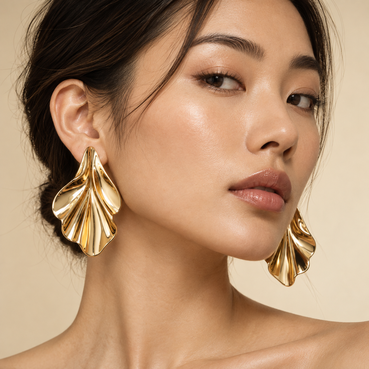 Light-olive-skinned non-Indian model showcasing bold gold earrings on bare ears